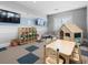 A cheerful playroom with playhouse, table and chairs, shelves of toys, and twin TVs at 16455 Whale Grey Pl, Bradenton, FL 34211