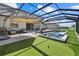 This screened-in lanai includes a stunning pool and spa with a putting green adjacent to the artificial turf at 16455 Whale Grey Pl, Bradenton, FL 34211