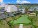 Aerial view of a putting green, community pool, and splashpad surrounded by lush landscaping and palm trees at 16455 Whale Grey Pl, Bradenton, FL 34211