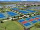 Overhead view of tennis and basketball courts in a planned community near residential homes and a scenic lake at 16455 Whale Grey Pl, Bradenton, FL 34211