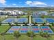 Aerial view of well-maintained tennis and basketball courts within a vibrant, landscaped community near a lake at 16455 Whale Grey Pl, Bradenton, FL 34211