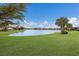 Backyard view with a scenic pond view showcasing the lush landscaping at 16719 Ellsworth Ave, Bradenton, FL 34202