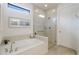 Elegant bathroom featuring soaking tub, walk-in shower with glass door, and light tile at 16719 Ellsworth Ave, Bradenton, FL 34202