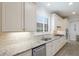Gourmet kitchen with stainless appliances, granite counters, white cabinetry, and tile backsplash at 16719 Ellsworth Ave, Bradenton, FL 34202