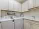 Functional laundry room with washer, dryer, and built-in sink at 16719 Ellsworth Ave, Bradenton, FL 34202