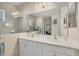 Bathroom with a double sink vanity, large mirror, updated lighting fixtures, and a walk-in shower at 21037 Anclote Ct, Venice, FL 34293