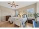 Well-lit bedroom with two beds, light walls, window shutters, ceiling fan, and wood laminate flooring at 21037 Anclote Ct, Venice, FL 34293