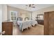 Bright bedroom showcasing two twin beds, neutral walls, wood laminate flooring, and a ceiling fan at 21037 Anclote Ct, Venice, FL 34293