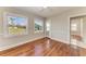 Bedroom with hardwood floors, two windows providing lots of natural light, and a ceiling fan at 2512 Riverside E Dr, Bradenton, FL 34208