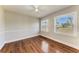 Cozy bedroom featuring hardwood floors, a ceiling fan, and windows overlooking the lawn at 2512 Riverside E Dr, Bradenton, FL 34208