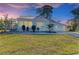 Charming home exterior with a metal roof, well-manicured lawn and landscaping under a gorgeous sunset sky at 2512 Riverside E Dr, Bradenton, FL 34208