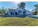 Charming home exterior with a metal roof, well-manicured lawn and landscaping under a gorgeous sunny sky at 2512 Riverside E Dr, Bradenton, FL 34208