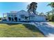 Charming home featuring a metal roof, white stucco exterior, and well-maintained landscaping at 2512 Riverside E Dr, Bradenton, FL 34208