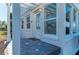 Inviting front porch with detailed tile flooring, classic white columns and sunroom windows, creating a cozy entrance at 2512 Riverside E Dr, Bradenton, FL 34208