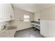 Large laundry room featuring utility sink, storage cabinets, and tile flooring at 2512 Riverside E Dr, Bradenton, FL 34208