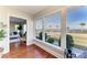 Bright sun room with hardwood floors and large windows with views of the water, perfect for relaxing indoors at 2512 Riverside E Dr, Bradenton, FL 34208