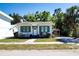 Charming single-story home with green shutters, a well-kept lawn, and mature trees at 2530 Loma Linda St, Sarasota, FL 34239