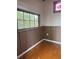 Corner view highlighting hardwood flooring, paneled walls, and a window with green outdoor views at 2530 Loma Linda St, Sarasota, FL 34239