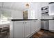 Kitchen with counter seating and stainless steel dishwasher and open shelving with dark stone countertops at 2530 Loma Linda St, Sarasota, FL 34239
