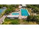 Aerial view of a large community pool with multiple lanes, surrounded by trees and tennis courts at 2530 Loma Linda St, Sarasota, FL 34239