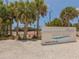 Siesta Beach sign with tennis courts and palm trees under a clear blue sky at 2530 Loma Linda St, Sarasota, FL 34239