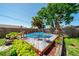 Backyard featuring an above-ground pool with a deck, surrounded by lush greenery and a wooden fence at 260 Hammock Ter, Venice, FL 34293