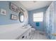Bright blue bathroom features a classic vanity and white tiled floor at 260 Hammock Ter, Venice, FL 34293