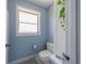 Bathroom featuring a toilet with blue walls, a small window, and white trim at 260 Hammock Ter, Venice, FL 34293