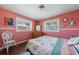 Cozy pink bedroom with a floral-patterned bed and a vintage dresser at 260 Hammock Ter, Venice, FL 34293