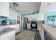 Bright kitchen features white cabinetry, stainless steel appliances, and tile backsplash at 260 Hammock Ter, Venice, FL 34293