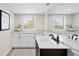 Bright bathroom with dual sinks, white cabinets, and granite countertops at 347 Ardenwood Dr, Englewood, FL 34223