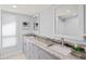 Bathroom featuring dual sinks, marble countertops, and a walk-in shower at 347 Ardenwood Dr, Englewood, FL 34223