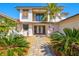 Charming front entrance with large double doors, stone walkway, and lush tropical plants at 347 Ardenwood Dr, Englewood, FL 34223