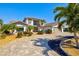 Beautiful home featuring palm trees, a paver driveway, and lush landscaping at 347 Ardenwood Dr, Englewood, FL 34223