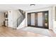 Inviting foyer with wood flooring, staircase, and a glimpse of the adjacent bar area at 347 Ardenwood Dr, Englewood, FL 34223