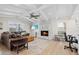 Spacious living room features a stone fireplace, light hardwood floors, and a ceiling fan at 347 Ardenwood Dr, Englewood, FL 34223
