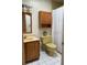 Traditional bathroom featuring white tile floor, oak cabinets, and a shower with white curtain at 411 El Greco Dr, Brandon, FL 33511