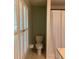 Small bathroom with a toilet, bifold shutters, and a shower with curtain at 411 El Greco Dr, Brandon, FL 33511
