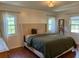 Bright bedroom with a large bed, hardwood floors, and three windows at 411 El Greco Dr, Brandon, FL 33511