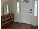 Inviting foyer featuring wood-look flooring, decorative mirror, and door with leaded glass sidelights at 411 El Greco Dr, Brandon, FL 33511