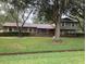 Charming two-story home with lush landscaping and mature trees on an expansive green lawn at 411 El Greco Dr, Brandon, FL 33511