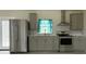 Modern kitchen featuring stainless steel appliances, gray cabinets, and a window above the sink at 411 El Greco Dr, Brandon, FL 33511