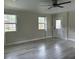 Well-lit room with light gray wood floors and ample natural light from two windows at 411 El Greco Dr, Brandon, FL 33511