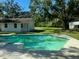 Backyard pool with a slide surrounded by a concrete deck and lush green lawn at 411 El Greco Dr, Brandon, FL 33511