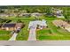 Aerial view of a well-maintained home with lush landscaping, long driveway, and mature trees at 4268 Mulgrave Ave, North Port, FL 34287