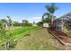 A spacious backyard featuring lush green grass, tropical foliage, and a storage shed at 4268 Mulgrave Ave, North Port, FL 34287