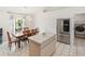 Bright eat-in kitchen with stainless steel refrigerator and view into the laundry room at 4268 Mulgrave Ave, North Port, FL 34287