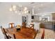 Dining room with modern lighting fixture, stainless steel refrigerator and view into kitchen at 4268 Mulgrave Ave, North Port, FL 34287