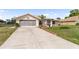Home's exterior showcasing the driveway, front yard, and a two-car garage at 4268 Mulgrave Ave, North Port, FL 34287