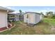 Backyard shed next to a screened-in lanai with pool, bordered with landscaping and a gravel walkway at 4268 Mulgrave Ave, North Port, FL 34287